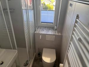 a small bathroom with a toilet and a window at Tief 12 Seeigel 31 in Wangerland