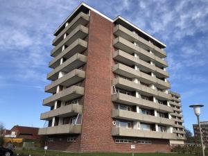 a tall red brick building with balconies at Tief 12 Seeigel 31 in Wangerland