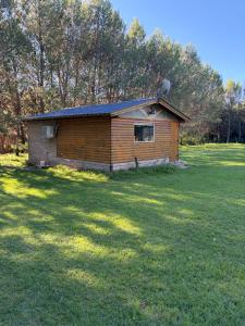 a small building in the middle of a grass field at cabañas los juanes in Tres Arroyos