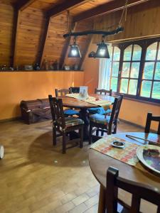 a dining room with a table and chairs and windows at cabañas los juanes in Tres Arroyos