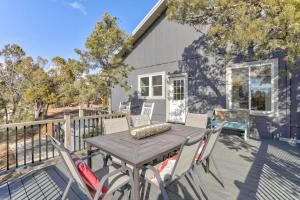 a wooden table and chairs on a deck with a house at Blue Betty Acre in Overgaard