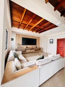 a living room with a white couch and a flat screen tv at Oceanfront House With Pool and BBQ in San Clemente