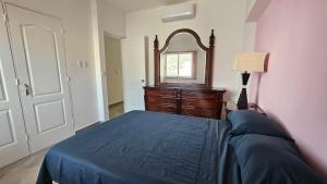 a bedroom with a bed and a dresser and a mirror at Comfortable apartment with pool, close to the beach in Acapulco +11 photos