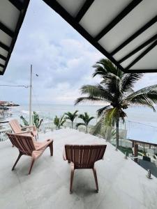 a patio with two chairs and a table and a palm tree at Oceanfront House With Pool and BBQ in San Clemente
