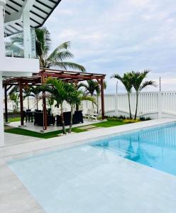 a pool at a resort with a pavilion and palm trees at Oceanfront House With Pool and BBQ in San Clemente