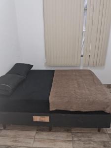 a bed in a room with a black bed frame at Pousada Paula Lima II in Juiz de Fora