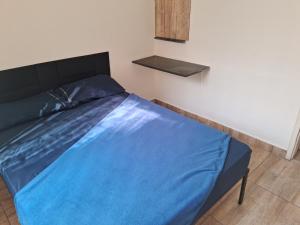 a bed with a blue sheet on it in a room at Pousada Paula Lima II in Juiz de Fora