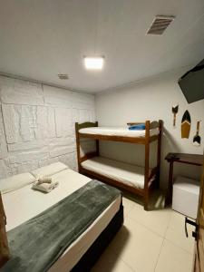 a bedroom with two bunk beds and a table at Ilha Grande Trip Economic in Abraão