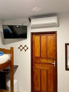 a room with a door and a television on the wall at Ilha Grande Trip Economic in Abraão