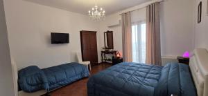 a bedroom with a blue bed and a couch at IL BORGO DEL BENESSERE in Rocca Imperiale