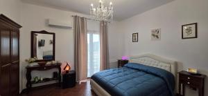 a bedroom with a blue bed and a mirror at IL BORGO DEL BENESSERE in Rocca Imperiale