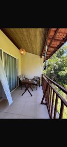a porch with a table and benches on a balcony at Flat Palmeira-Pipa Solar - centro in Tibau do Sul