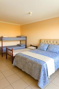 two beds in a room with two bunk beds at Pousada Recanto dos Pássaros in Linhares +8 photos