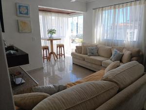 a living room with a couch and a table at Apartamento Praia de Porto Belo, Balneario Pereque, SC in Porto Belo