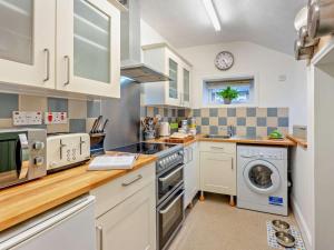 a kitchen with white cabinets and a washer and dryer at 3 Bed in Ventnor oc-93525 in Niton +18 photos
