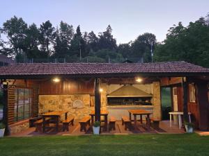 a pavilion with tables and a grill in a yard at Hotel La Cumbrecita in La Cumbrecita