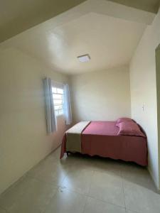 a bedroom with a bed in a room with a window at Apartamento Salinas in Cacoal