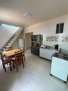 a kitchen with a wooden table and a kitchen with a staircase at Apartamento Salinas in Cacoal