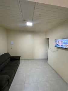 a living room with a couch and a flat screen tv at Apartamento Salinas in Cacoal