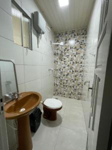a bathroom with a wooden sink and a toilet at Apartamento Salinas in Cacoal +20 photos