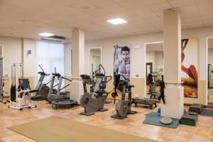 a gym with cardio equipment and a man on the wall at Borgo San Giorgio by La Principina in Grosseto
