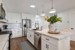 a kitchen with white cabinets and a vase of flowers on the counter at Courtyard-Patio-Moutain and V3872-Holly House in Palm Desert