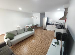 a living room with a couch and a kitchen at Refúgio Machiquense in Machico