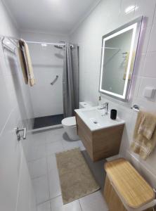a bathroom with a sink and a toilet and a mirror at Refúgio Machiquense in Machico +22 photos