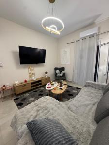a living room with a couch and a tv at Gemini Downtown Apartment in Zakynthos