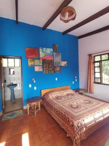 a bedroom with a bed and a blue wall at El Cafetal in Coroico