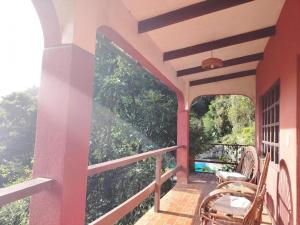 a balcony of a house with a table and chairs at El Cafetal in Coroico