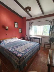 a bedroom with a bed in a red wall at El Cafetal in Coroico +7 photos