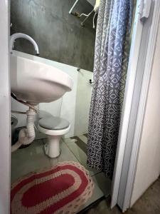 a bathroom with a sink and a toilet and a shower curtain at Camping e Pousada do Ade in Ilha do Mel +60 photos