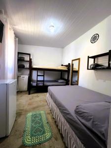 a bedroom with a bed and a green rug on the floor at Camping e Pousada do Ade in Ilha do Mel