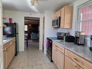 a kitchen with wooden cabinets and a counter top at Tory Hill in Hillsdale +7 photos