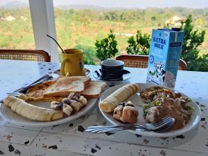 two plates of food on a table with breakfast foods at Traveling Guest House - Shared Kitchen in Kuta Lombok