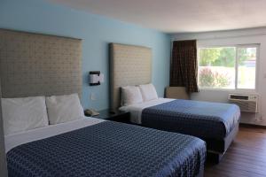 a hotel room with two beds and a window at Torch Lite Lodge in Yuma +27 photos