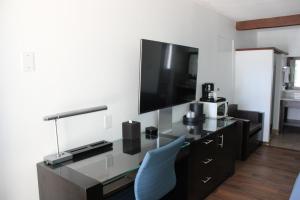 a room with a desk with a tv and a blue chair at Torch Lite Lodge in Yuma