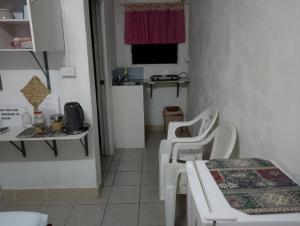 a small room with two white chairs and a table at Kathy B Guesthouse in Luganville