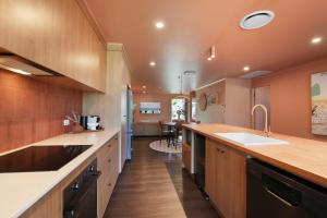 a large kitchen with wooden cabinets and a sink at Amity Duo - Roys in Amity Point