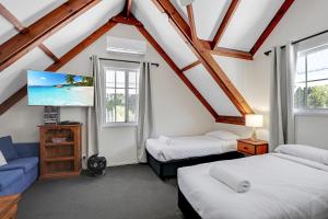 a attic room with two beds and a tv at Amity Oasis in Amity Point