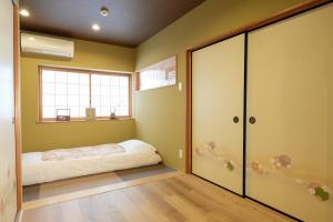 a bedroom with a bed and a window at 嵐lan in Kyoto