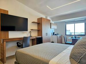 a bedroom with a bed and a flat screen tv at Hotel Casa Cristales in Cali