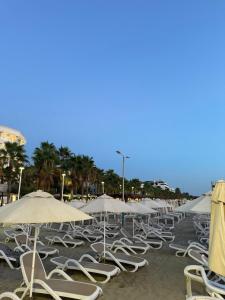 a row of chairs and umbrellas on a beach at Gees House in Golem