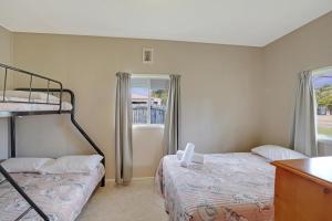 two beds in a room with two windows at Betty's Place in Amity Point