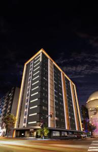 a tall building at night with a street at Randor Hotel Sapporo Heritage in Sapporo