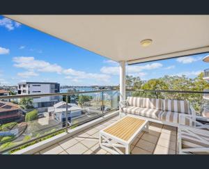 a balcony with a bench and a view of the city at Walk to Beach • Luxury Waterfront Penthouse in Mooloolaba