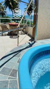 a pool on the side of a resort with a table at Pousada Tábua das Marés in Japaratinga