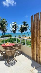 a patio with a table and chairs and the ocean at Pousada Tábua das Marés in Japaratinga