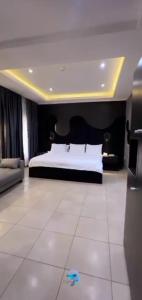 a large bedroom with a bed and a tiled floor at Triple 9 Apartments,Pool & Spa in Abuja